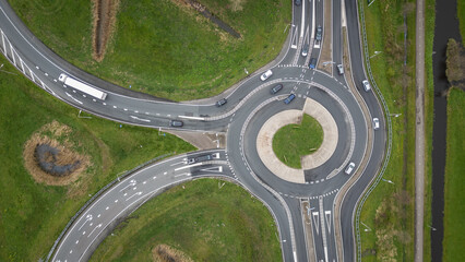 Dutch roundabout on road N459 from A12 at Reeuwijk near Gouda in Netherlands. Traffic flows at efficient pace with cars in highway lanes entering and exiting motorway. drone aerial view of transport
