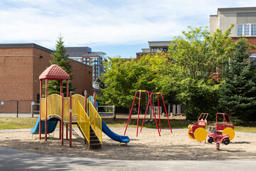 Children playground in park near schoolyard. Summer break in school.