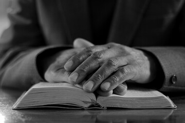 praying to God with the bible on black background with people stock image stock photo