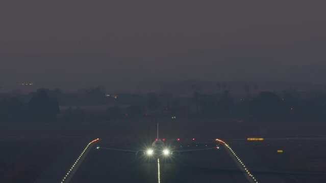 Airplane ascending from runway with navigation lights on at dusk
