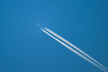 Avion à réaction avec traces blanches sur un ciel bleu