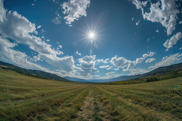 Fisheye Lens Landscape of Sun Shining Over Green Field and Mountains with Blue Sky and Clouds