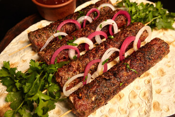 Kebab: grilled sausages on skewers of minced meat with pita bread and barbecue sauce decorated with...