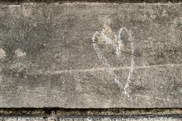 Heart shape drawn with white chalk on a rough rock surface