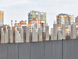 Concrete piles against the background of new buildings
