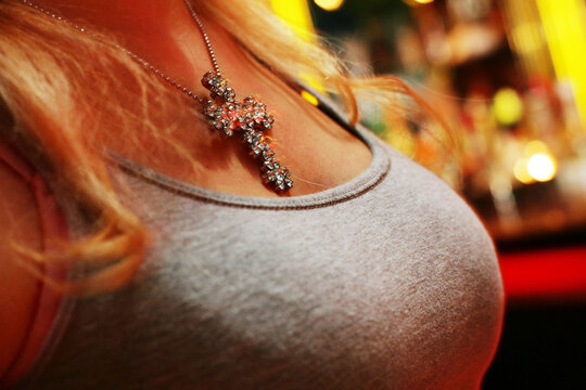 Junge frau tr&auml;gt Silberschmuck, eine Halskette mit Kreuz auf einer Party.