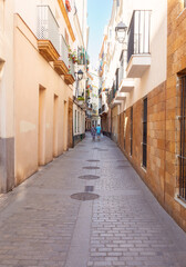 Old narrow traditional street in Cadiz at dawn. - obrazy, fototapety, plakaty