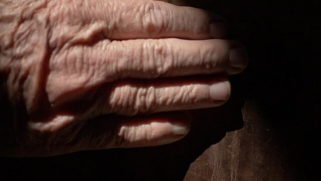 Hand of a old man passing on copper texture of a Cachaça Machine