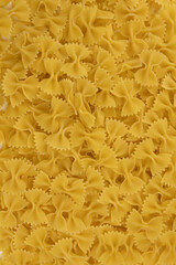 Obraz premium Background of raw Italian farfalle pasta close-up. Concept of pasta production.
