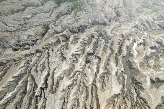 A captivating aerial perspective of the grooved terrain formed by erosion in a volcanic ash valley, displaying unique geological patterns