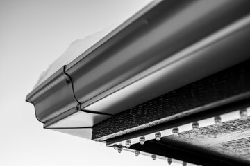 Underside of a roof gutter with permanent holiday LED lighting being installed. 
