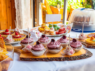 Cherry muffins and other delicious pastries are offered as a buffet at a party