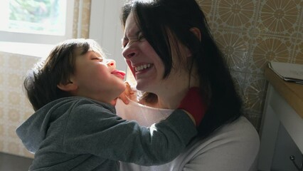 Funny and Cute Moment of Child Playfully Kissing Mother on Cheek with Tongue, Capturing Authentic Family and Motherhood Scene, Little Boy Bonding with Parent