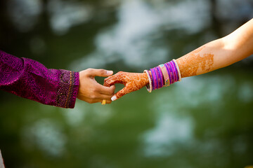 Indian bride and groom hold hands before wedding reception