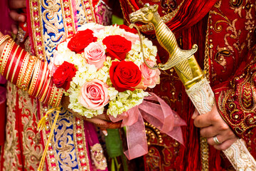 Sikh bride and groom with sword and bouquet