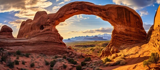 The large arch stands prominently in the desert landscape, framed by the vast blue sky in the background