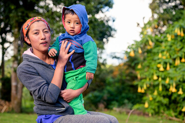 Farmer mother poses with her son for a portrait in a rural community in Latin America