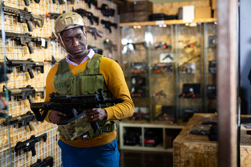 African american man in army uniform with weapon in military market