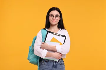 Tuinposter Student with notebooks and clipboard on yellow background © New Africa
