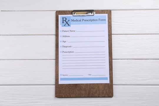 Medical prescription form with empty fields on white wooden table, top view