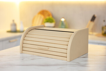 Wooden bread box on white marble table in kitchen, closeup