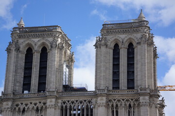 Sideview of Notre-Dame under blue sky with sparse clouds