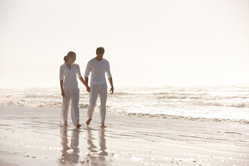 Couple, ocean and holding hands while walking on beach, travel and commitment with trust and bonding outdoor. Love, care and support in relationship, honeymoon or anniversary with peace in nature