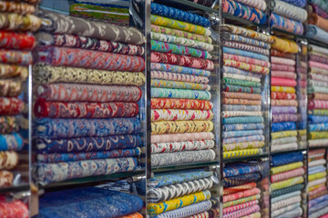 Indian textiles for saris with variety of colors shown in shop at local market