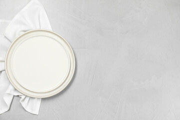Elegant plate and napkin on grey table, top view. Space for text