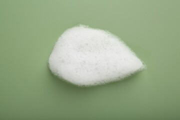 Sample of fluffy foam on green background, top view