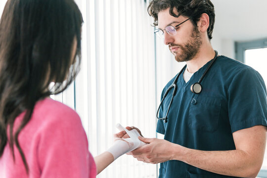 Focused image of a medical professional securing a bandage on the wrist of a patient, ensuring proper wound care