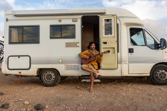 Nomadic Musician Creating Melodies by the Sea at Sunset - Powered by Adobe