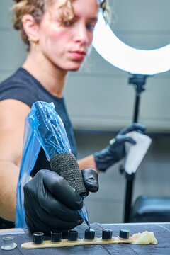 Female tattoo artist preparing ink for session