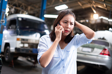 Woman talking on cellphone after car breakdown trouble problem mechanic. Woman dialing on cellphone...