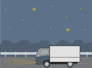夜にライトをつけて道路を走るトラック