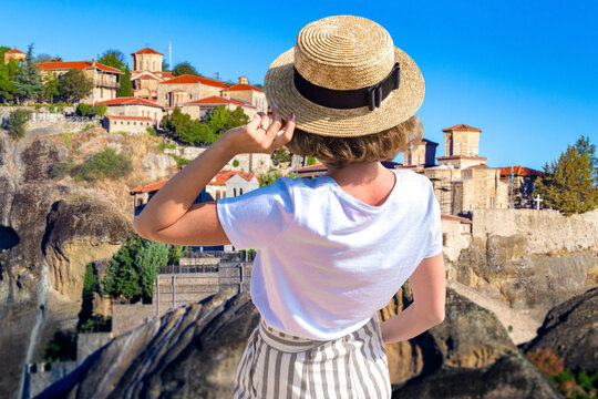Woman tourist in Cyprus. Girl with her back to camera. Woman admires houses on cliffs. Traveler near resort of Pissouri. Tourist on island of Cyprus. Holidays in village of Pissouri.