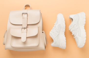 White woman trendy sneakers and bag on color background, top view