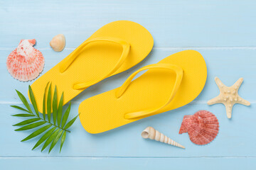 Bright yellow flip-flops on wooden background, top view. Summer concept