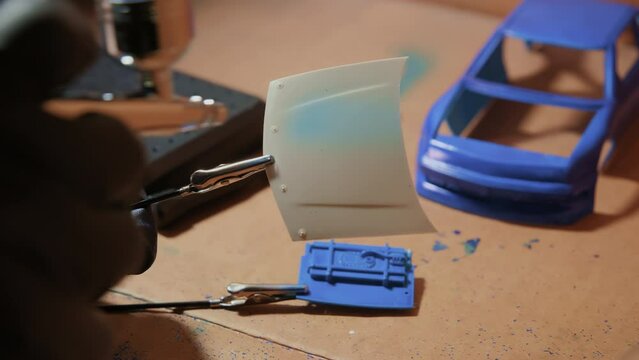 Man painting of airbrush plastic model of car. Hobby time. Close up footage
