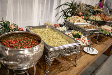 wooden table with stainless steel Richo with various types of food
