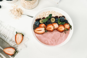 Presented by fruits putting yogurt toppings with strawberry, berry, oats, raisins and chia seed...