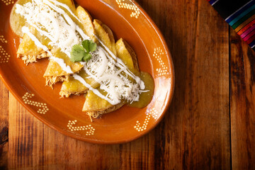 Green enchiladas. Typical Mexican dish made with a folded or rolled corn tortilla filled with...