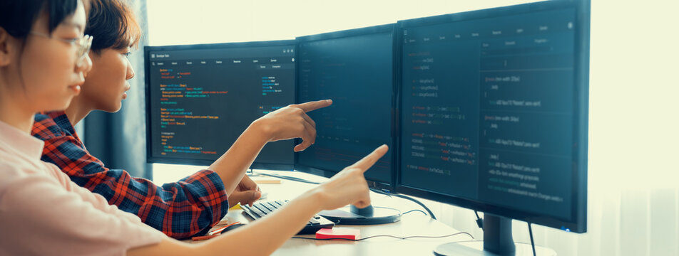 Cropped image of professional programer team collaboration discuss about web coding while coworker point java script displayed on computer at modern company office. Closeup. Burgeoning.
