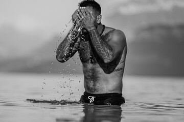 Strong muscular Man in water. Sexy male body with bare muscular naked torso. Summer relaxation...