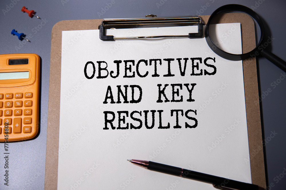 Poster objective key results okr text in the office notebook. view from above
