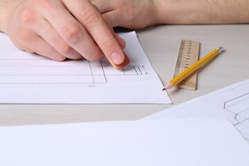 Man creating packaging design at light wooden table, closeup