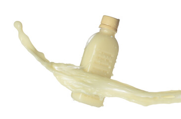 Tofu Soybean soymilk pour fall down in bottle container. Soybean milk or cosmetic cream moisturizer spill splash as paint color. White background isolated high speed shutter freeze motion