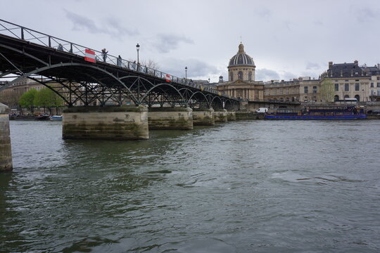 Landscape photo of River Seine with bridge, old-fashioned building in background, cloudy sky