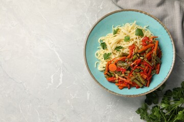 Vegetarian meal. Tasty pasta with vegetables on light grey marble table, top view. Space for text