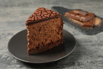 Piece of delicious chocolate truffle cake on grey textured table, closeup